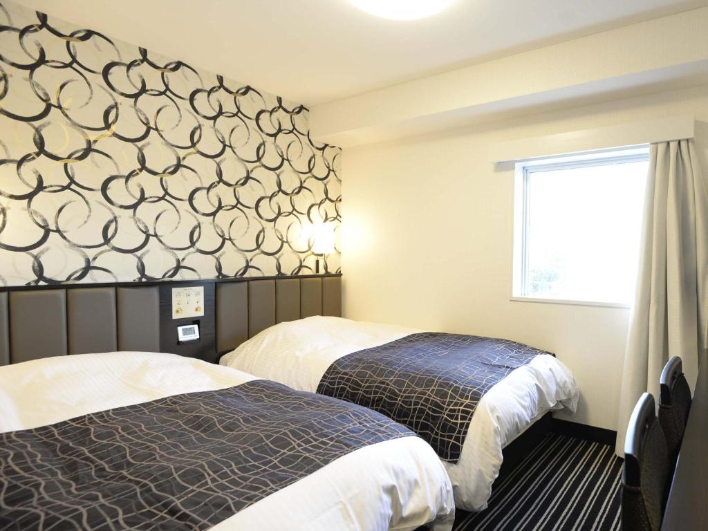 Postel nebo postele na pokoji v ubytování APA Hotel Mito-eki Kita