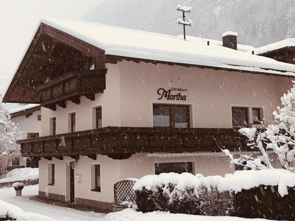 un edificio cubierto de nieve con un cartel. en Apartment Martha, en Mayrhofen