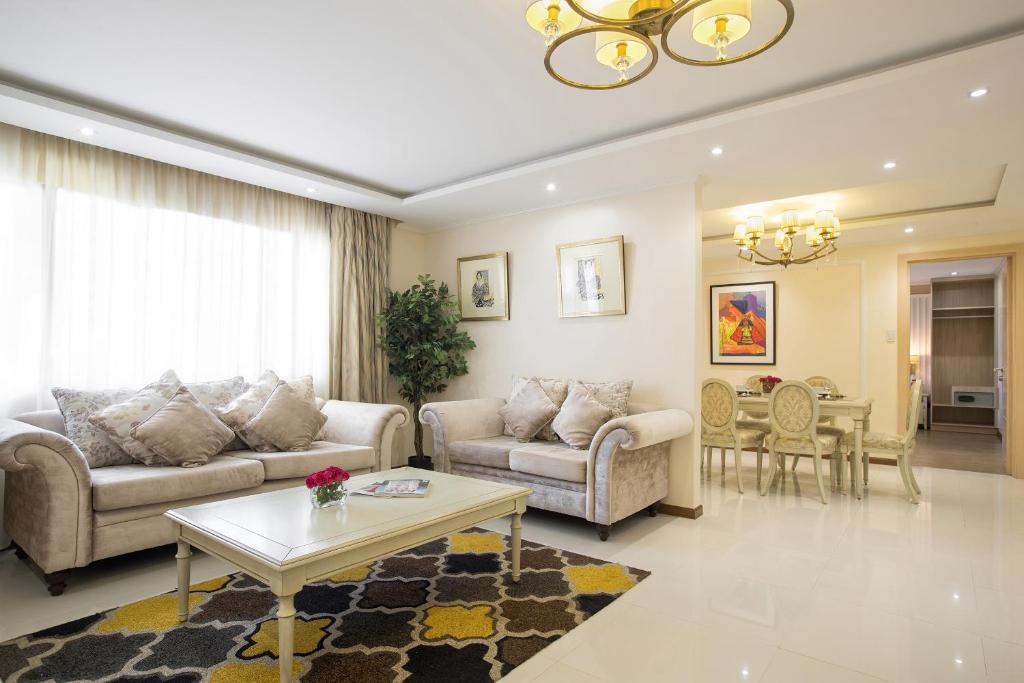 a living room with two couches and a table at Golden Prince Hotel & Suites in Cebu City