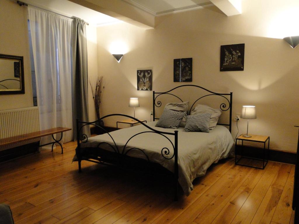 Un dormitorio con una cama negra con almohadas. en Chambres d&#39;hôtes Belle Occitane, en Tarascon-sur-Ariège