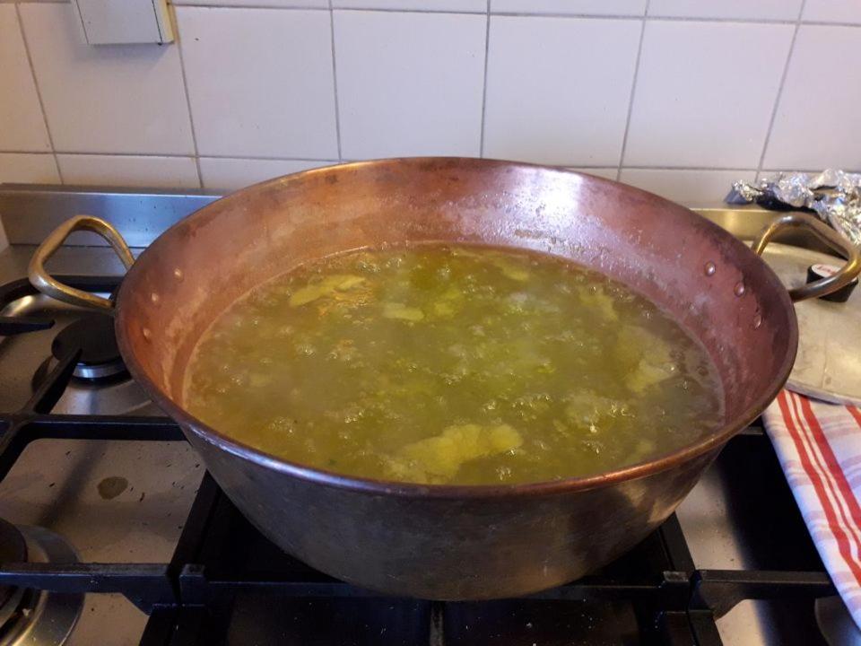 a pot of soup sitting on a stove at Chambres d'hôtes Belle Occitane in Tarascon-sur-Ariège