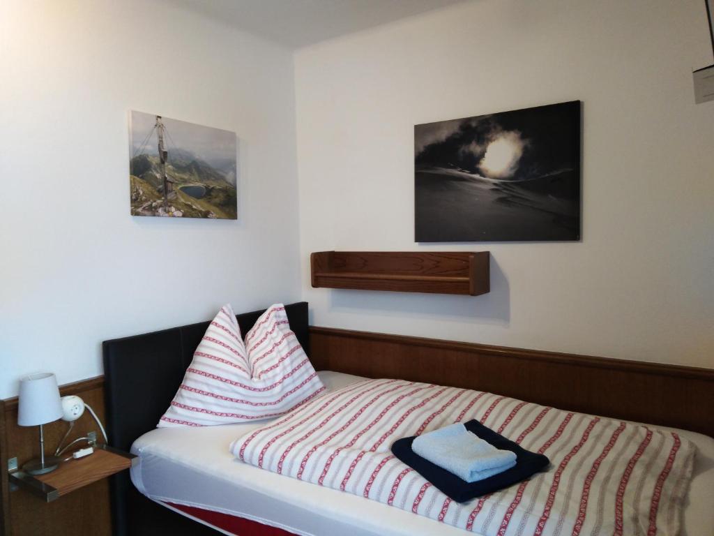 アルテンマルクト・イム・ポンガウにあるPrivatzimmervermietung Wiederkehrのベッドルーム1室(壁に2枚の写真が飾られたベッド1台付)