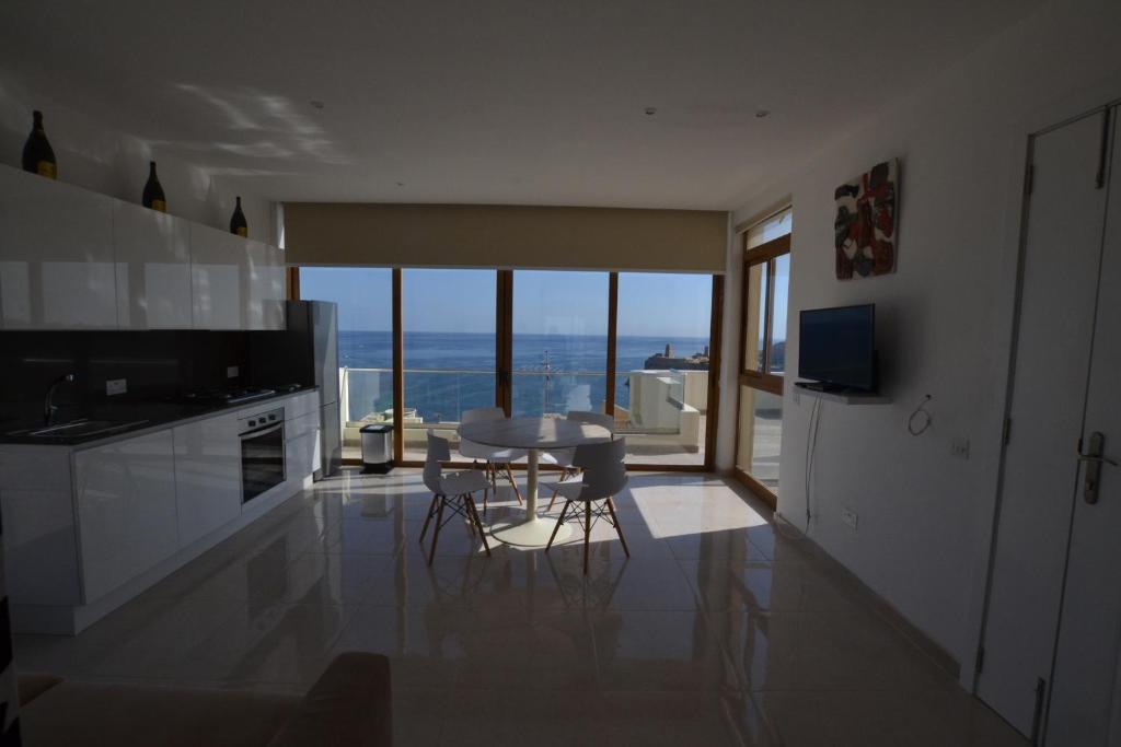 a kitchen with a table and a view of the ocean at Valletta Dream Suites Penthouse in Valletta