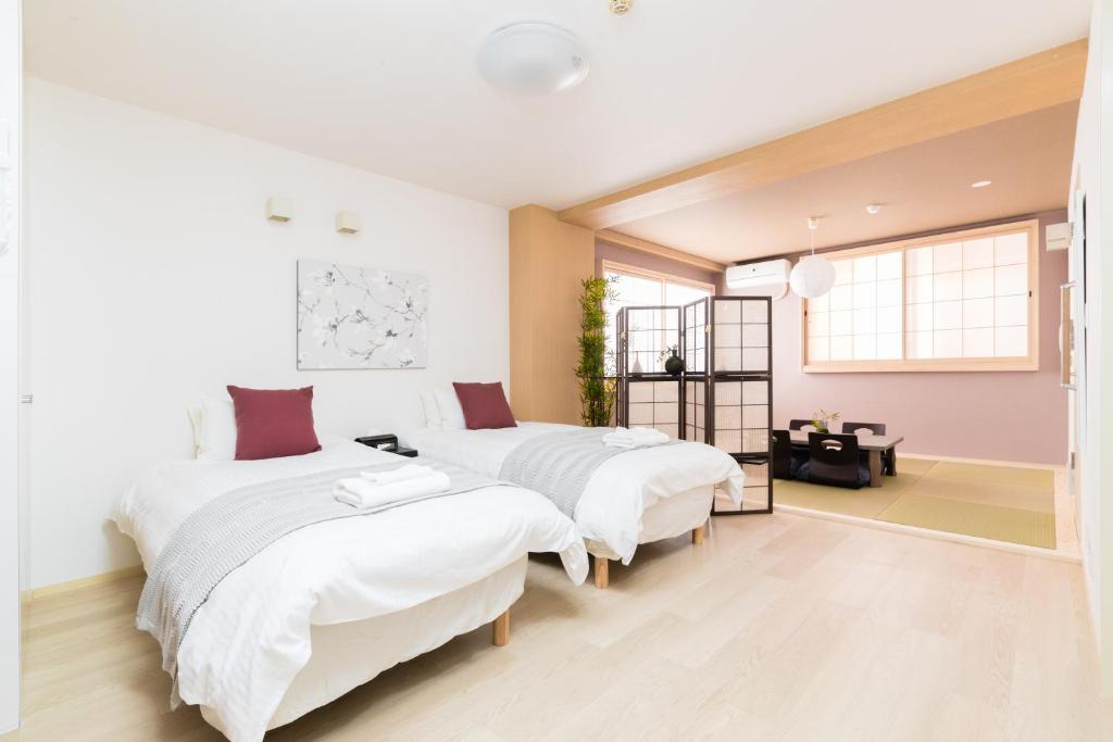 a bedroom with two beds and a window at GuestHouse MIYABI in Kyoto