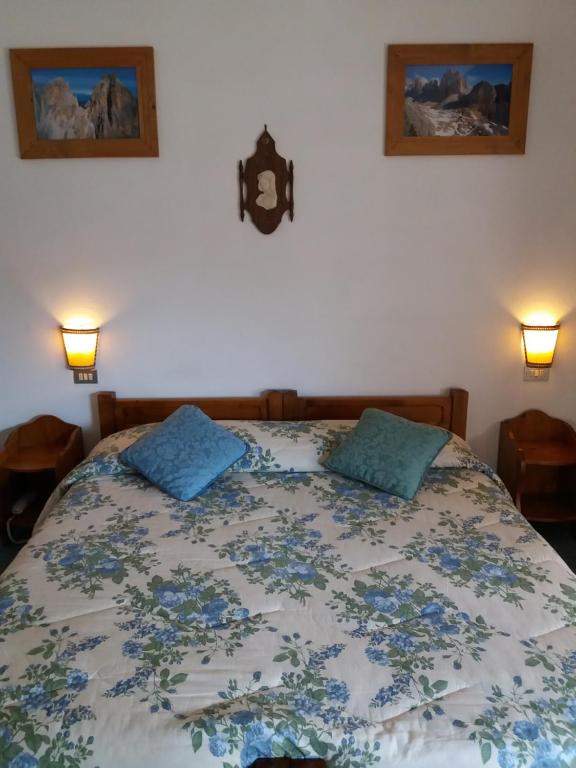 un letto con due cuscini blu sopra di Meublè Barancio a San Vito di Cadore