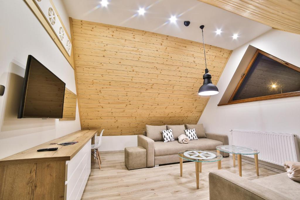 Televízia a/alebo spoločenská miestnosť v ubytovaní Apartamenty Kościelisko