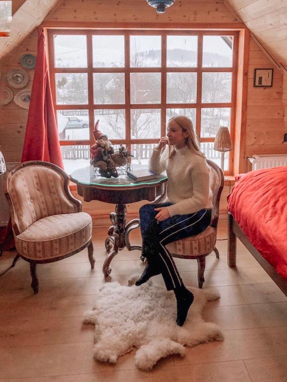 a woman sitting at a table in a room at Brvnare Mrkic in Kremna
