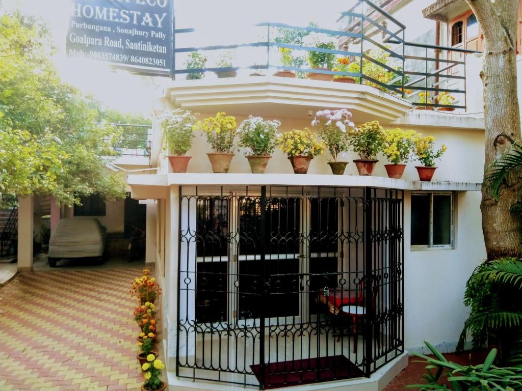 um edifício com vasos de plantas numa varanda em Chaiti Eco Homestay- Santiniketan Bolpur em Bolpur