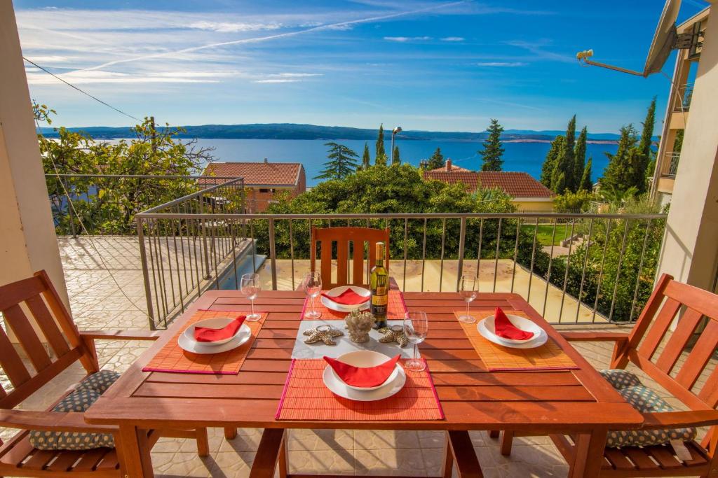 a wooden table with watermelons on it on a balcony at Apartments Maris in Crikvenica