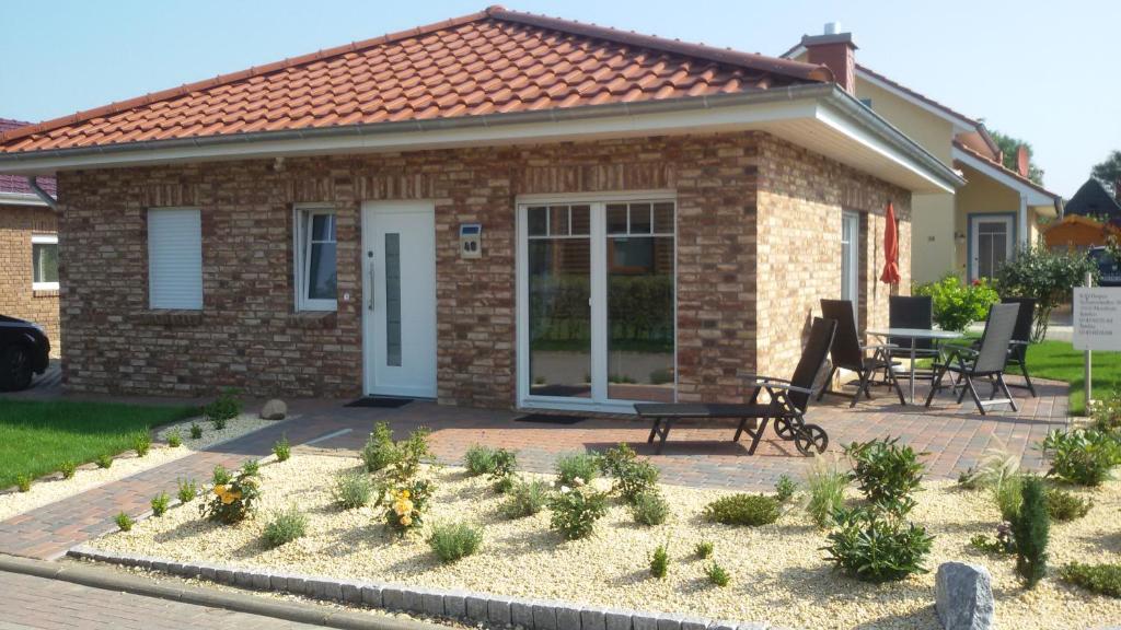 a small brick house with a table and a bench at Villa Belair Schmidt in Dorum-Neufeld