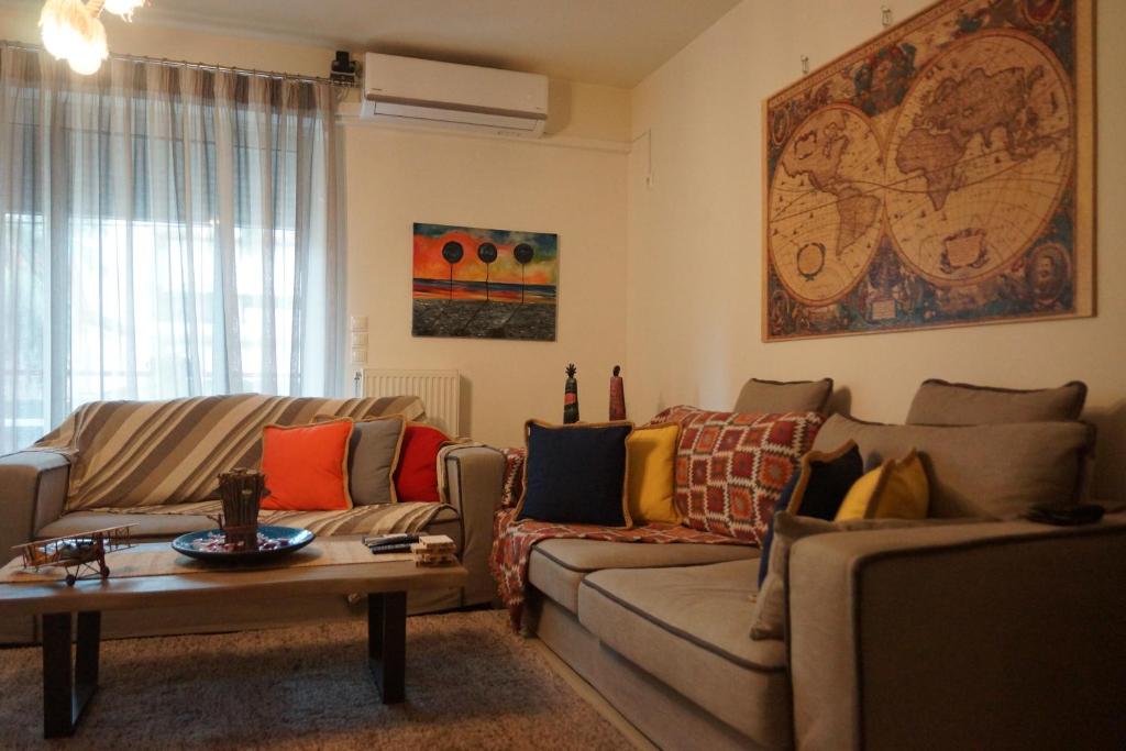 a living room with two couches and a table at Georgina's cozy apartment -Metropolitan Hospital- in Piraeus