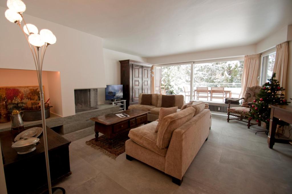 sala de estar con sofá y chimenea en La Villa Emeline - Apartment Emilie, en Zermatt