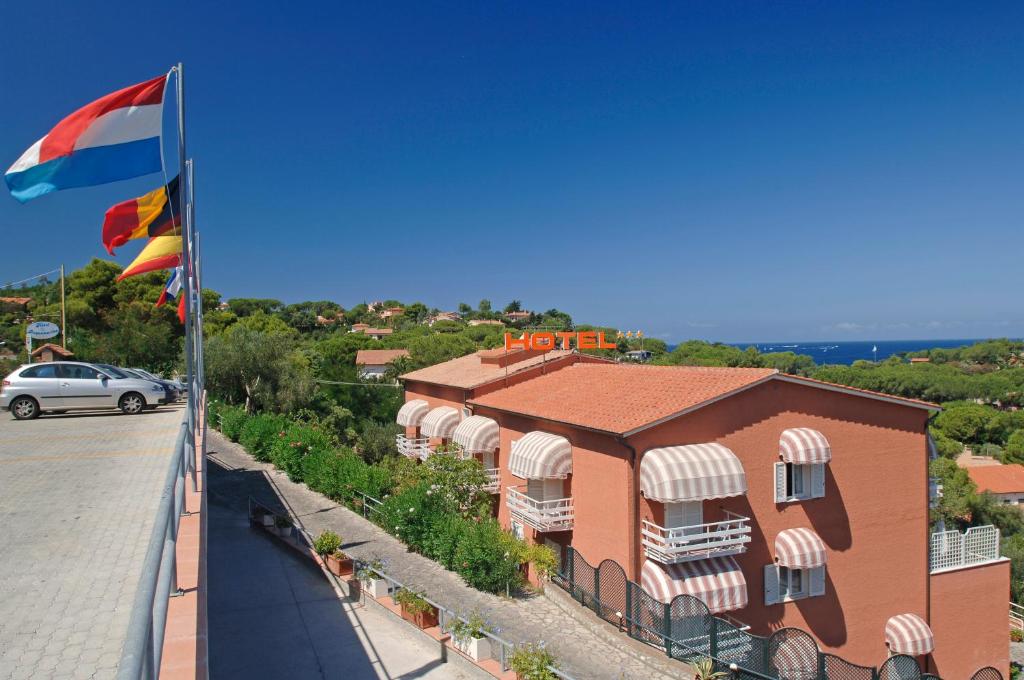 a flag on top of a building with a car at Hotel Acquamarina in Portoferraio