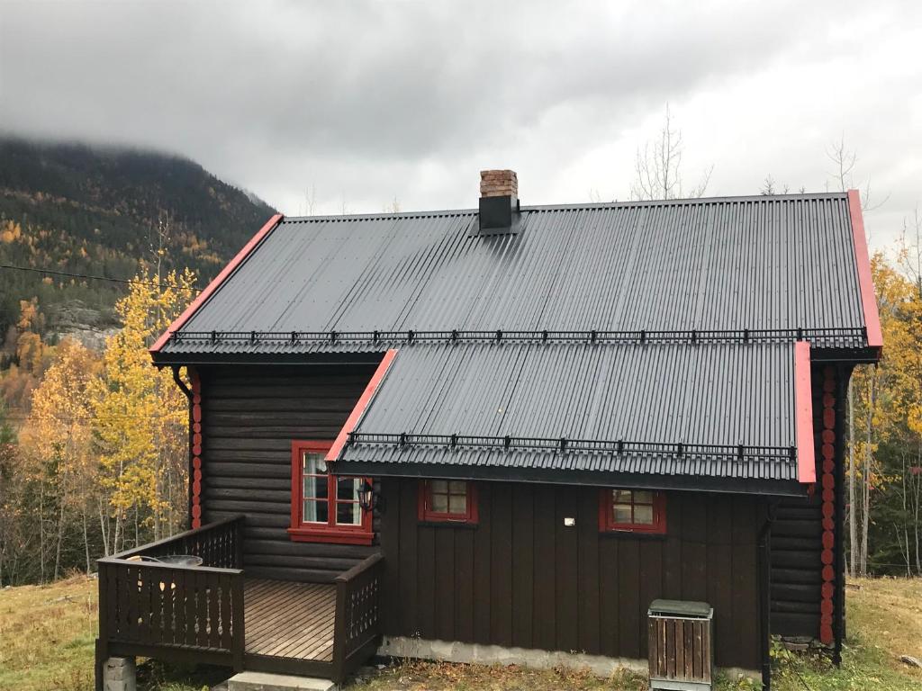 Tuddal的住宿－Løngdal，小木屋设有黑色屋顶和门廊