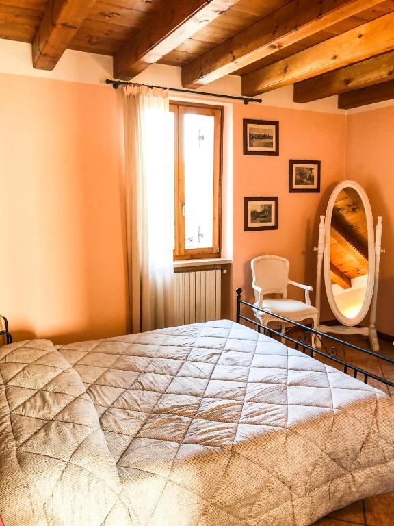 sypialnia z dużym łóżkiem i lustrem w obiekcie Le Finestre Su Borghetto w mieście Valeggio sul Mincio