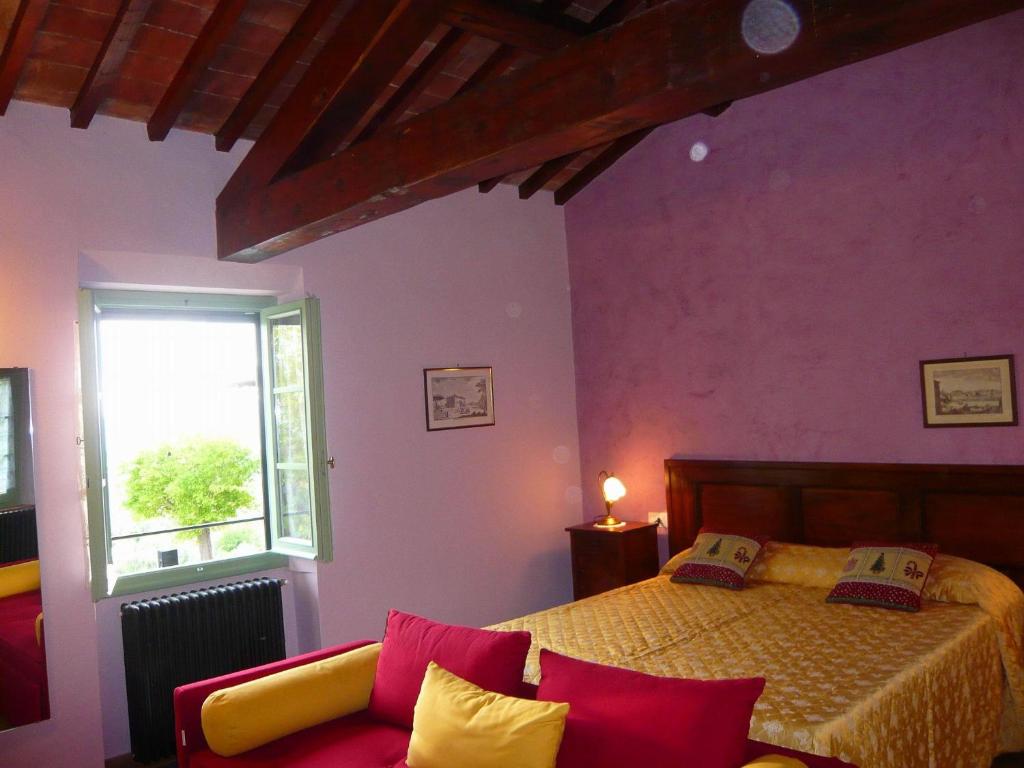 ein Schlafzimmer mit einem Bett, einem Fenster und einem Sofa in der Unterkunft La Pietra Piana B&B in Reggello