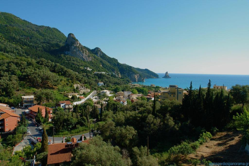 une ville sur une colline à côté de l'océan dans l'établissement Panorama apartments, à Agios Gordios