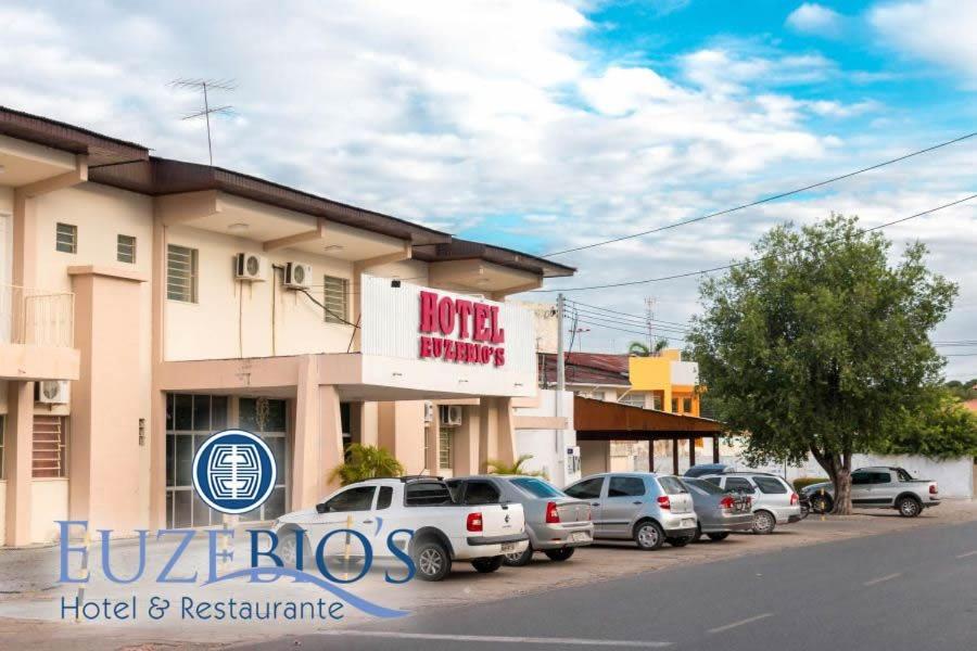 a hotel with cars parked in front of a building at Hotel Euzebio´s in Boa Vista