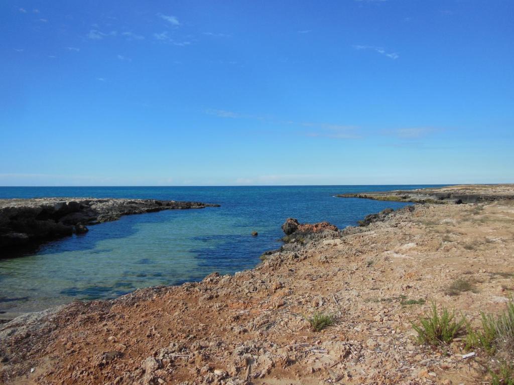 a large body of water next to a rocky shore at Residence Club Barbara in Ostuni
