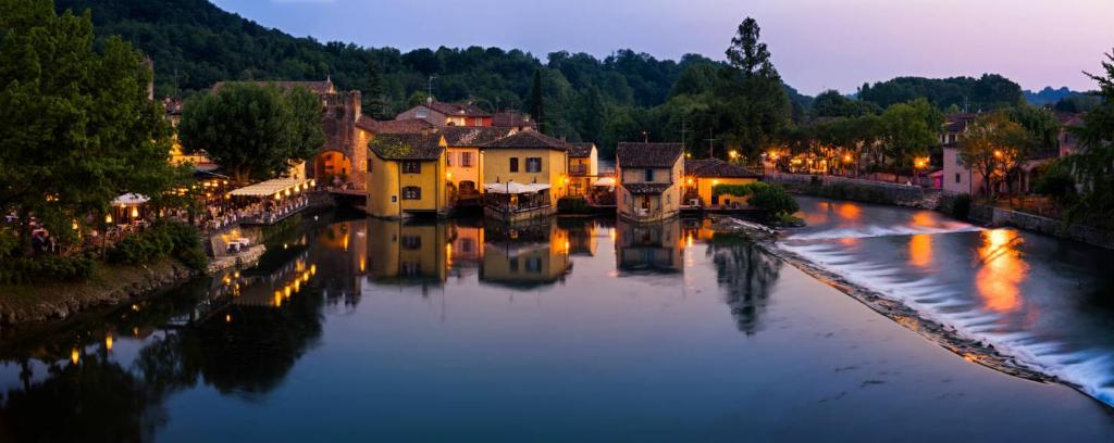 a view of a river in a town at night at Le Finestre Su Borghetto in Valeggio sul Mincio