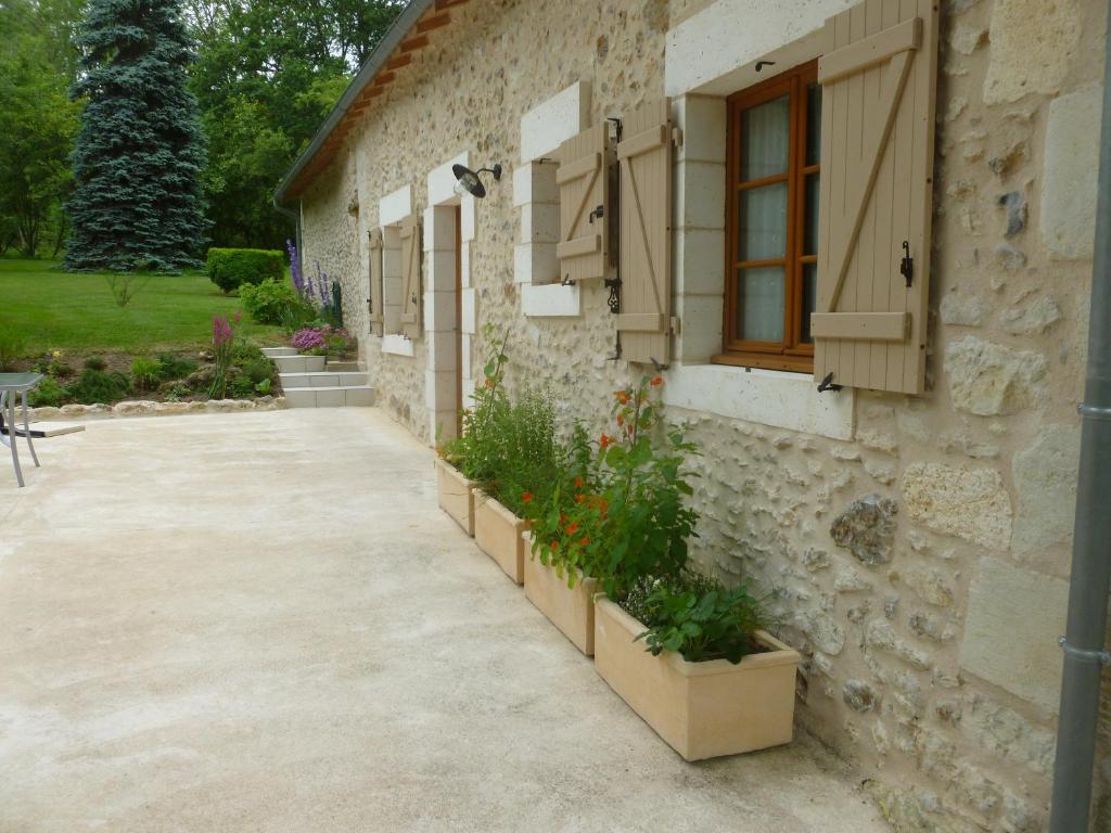 a stone building with a window and some plants at Gite de la Petite Burnie in Biras