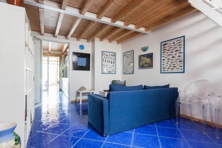 a living room with a blue couch and blue tiles at Le Case di VirGin 1 in Castellammare del Golfo
