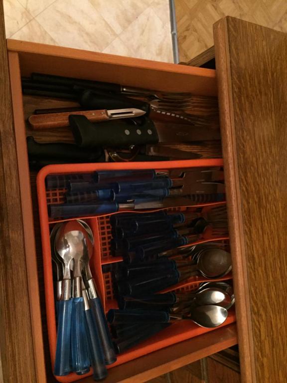 a drawer full of utensils in a wooden cabinet at Les Galets in Tracy-sur-Mer