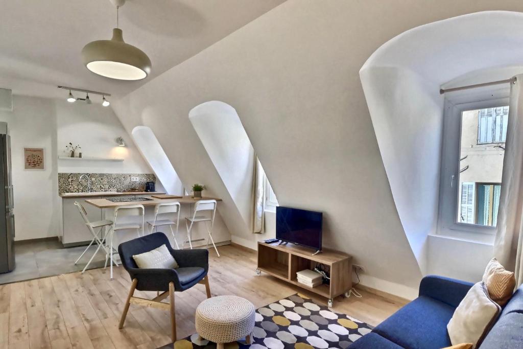 a living room with a couch and a table with chairs at Les appartements d'Edmond Saint Suffren in Marseille