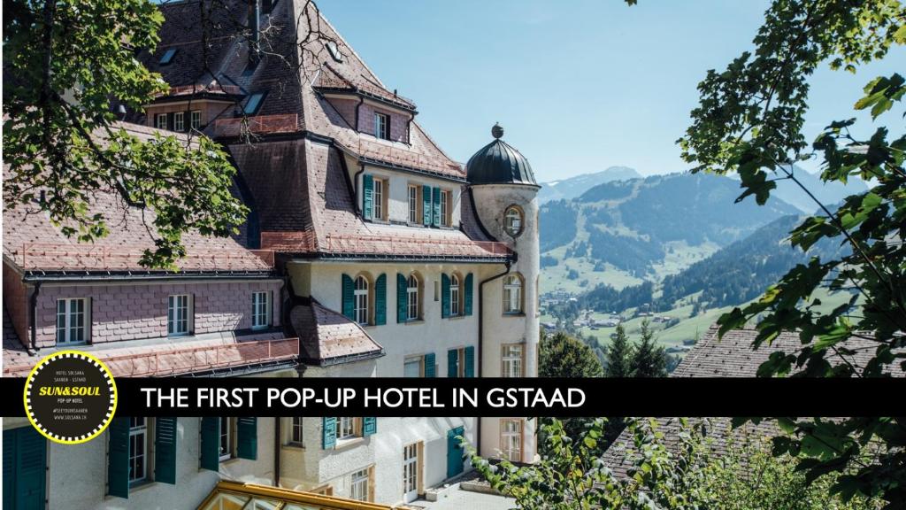 a large building with a clock on top of it at The Sun&Soul Panorama Pop-Up Hotel Solsana in Gstaad
