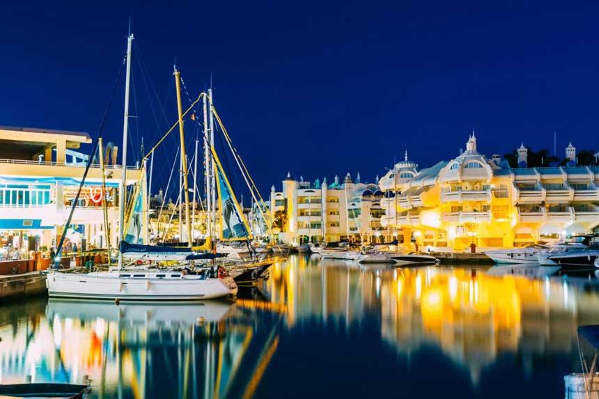 um grupo de barcos ancorados numa marina à noite em Apartamento Marina Suite em Benalmádena