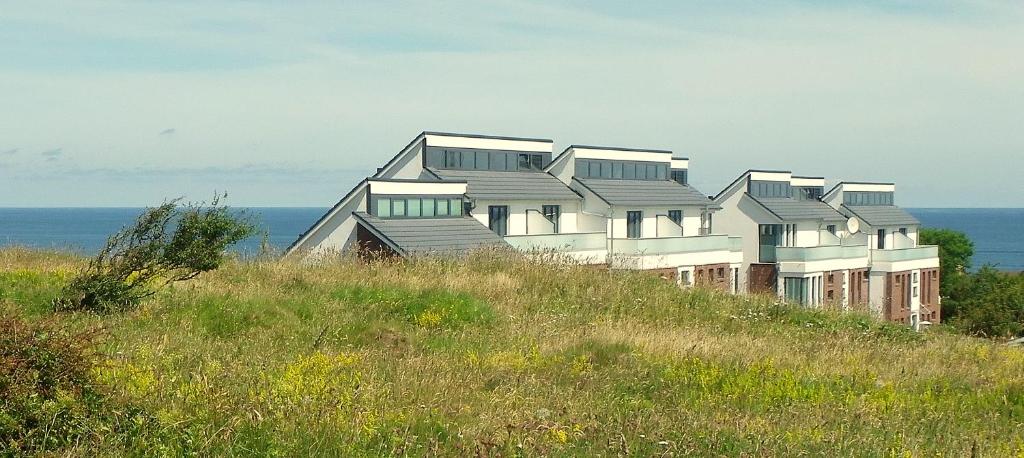 ein Gebäude auf einem Hügel mit dem Ozean im Hintergrund in der Unterkunft Meermomente in Helgoland
