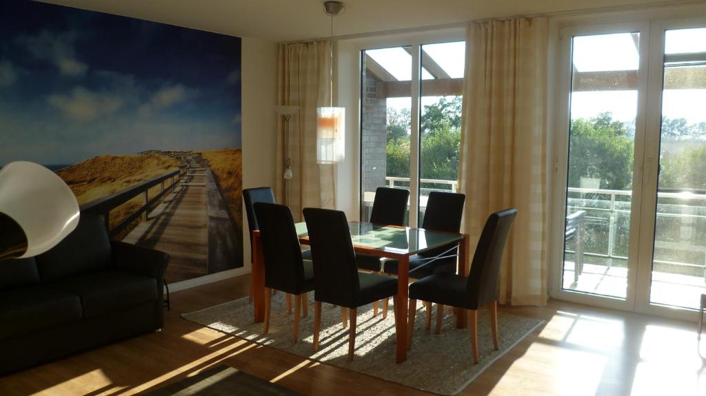 a dining room with a table and black chairs at Fuchs und Elster in Hohenkirchen