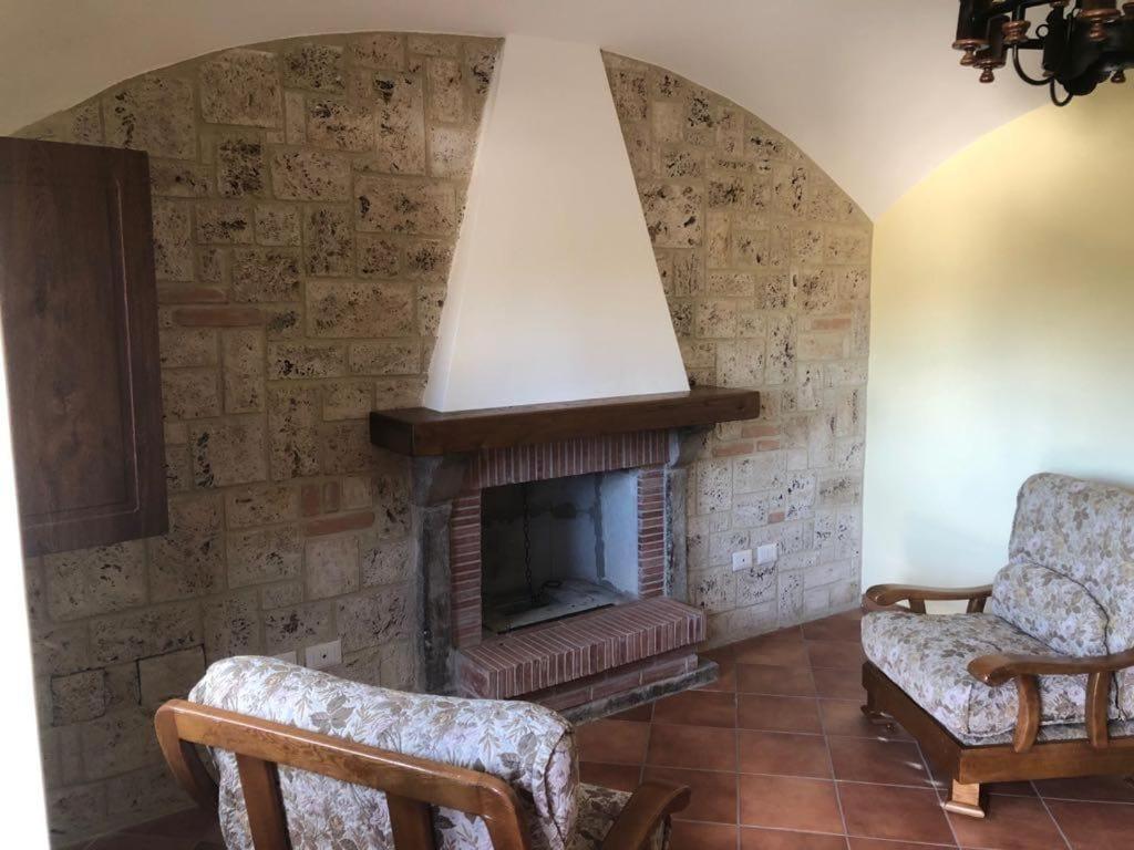 a living room with a fireplace and two chairs at La Sorgente Alta in Rocchetta a Volturno