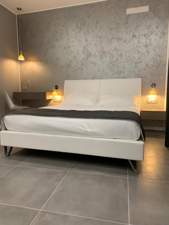 a white bed in a room with two lamps at ApartHotel Bossi in Milan