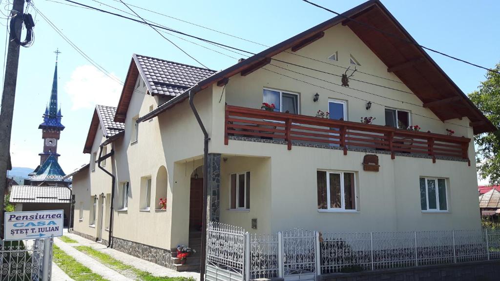 ein weißes Haus mit einem Zaun davor in der Unterkunft Pensiunea Casa Șteț Toader Iulian in Săpânța