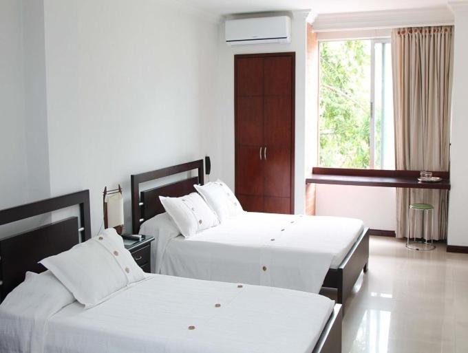 A bed or beds in a room at Pampalinda Hotel