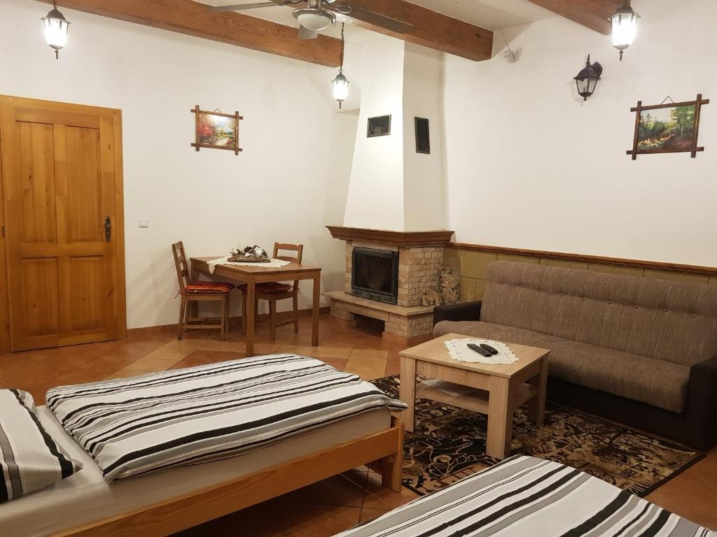sala de estar con sofá y chimenea en Ubytovanie pod Hradom, en Sklené Teplice