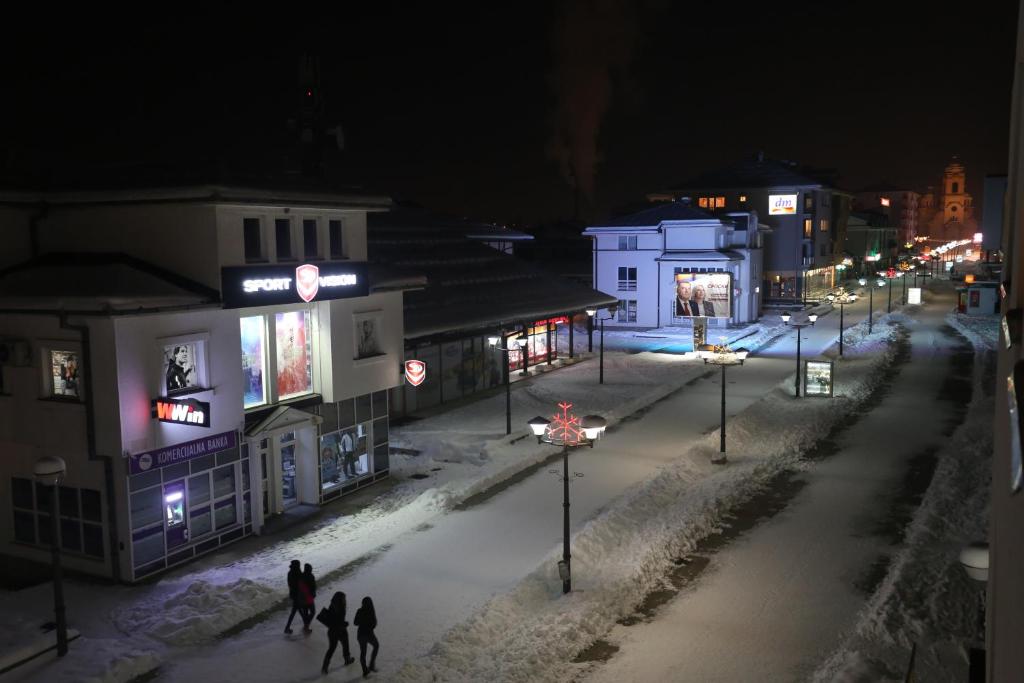 a group of people walking down a snow covered street at night at Snowball in Pale