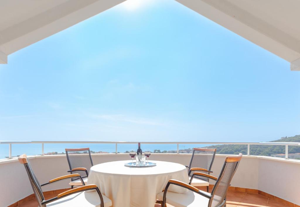 una mesa y sillas en un balcón con vistas al océano en Mediterranean Blue Apartments, en Dubrovnik