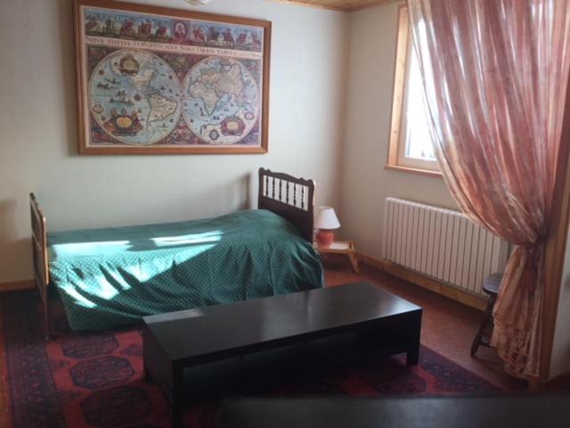 - une chambre avec un lit, une table et une fenêtre dans l'établissement Gîte Les Montagnes, à Bolandoz