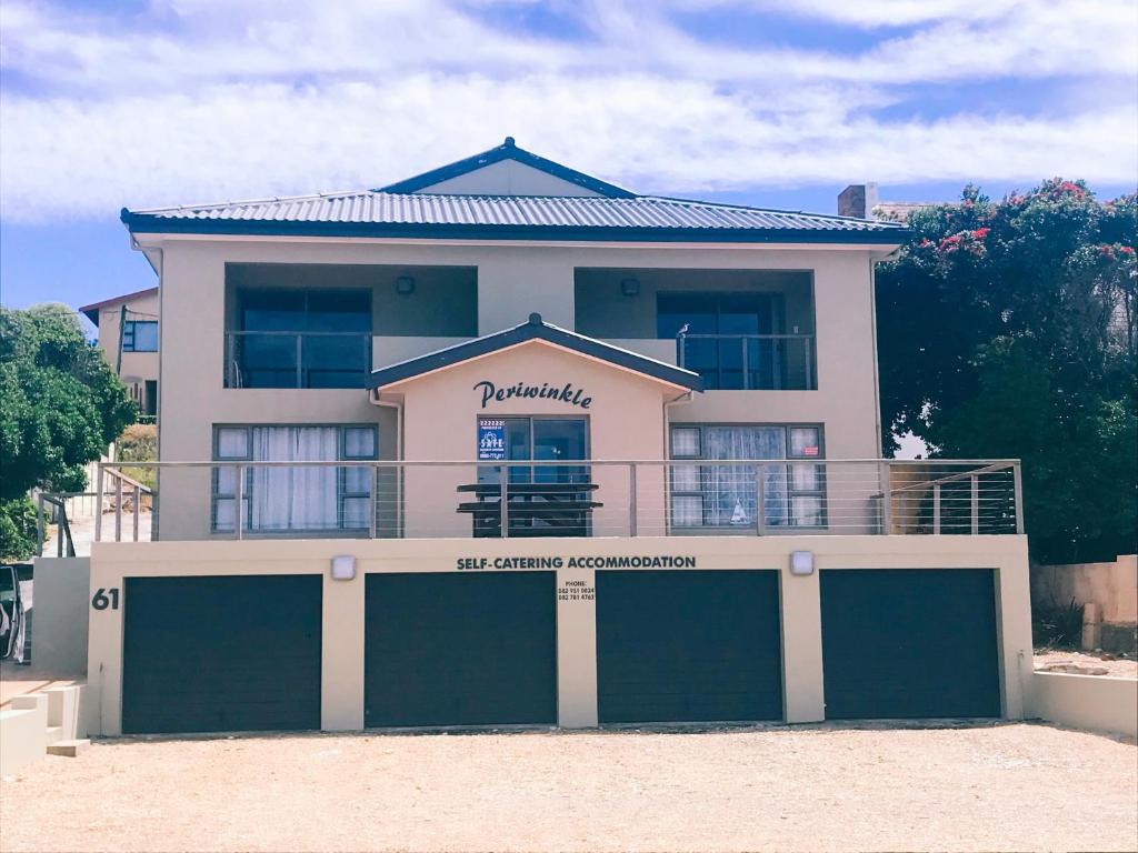 a house with two garage doors in front of it at Periwinkle Selfcatering 8 in Franskraal