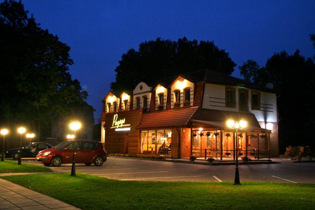 a building with lights in a parking lot at night at B&B Pagėgė in Pagėgiai