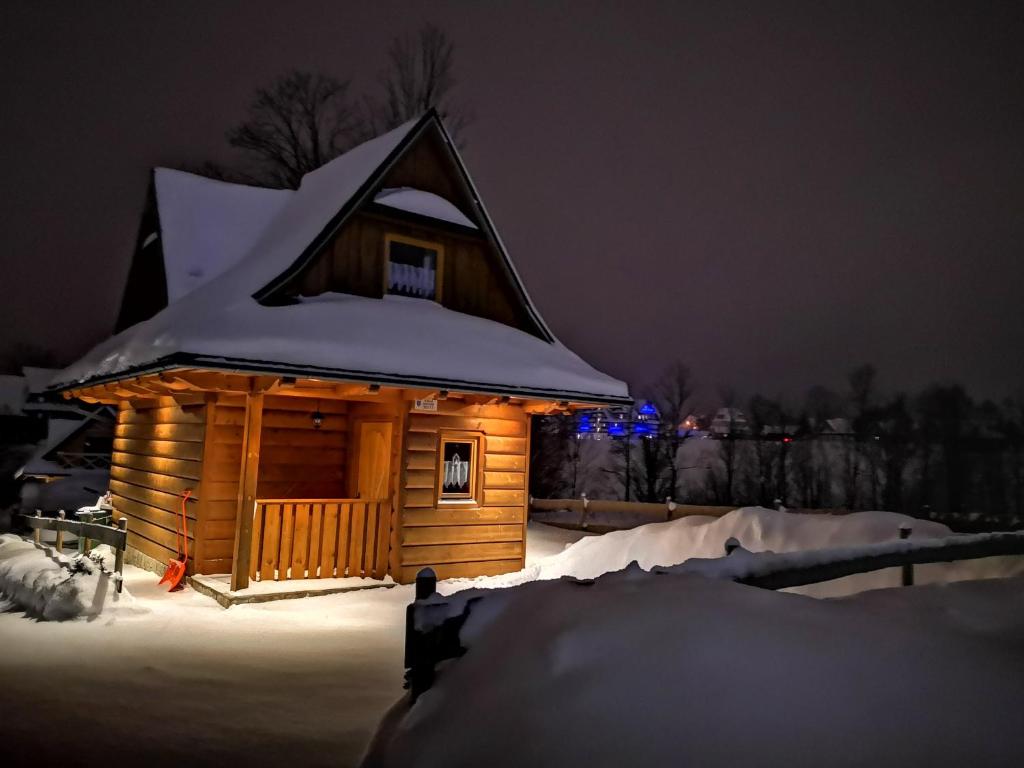 a small cabin covered in snow at night at Podhalańska Chatka in Zakopane