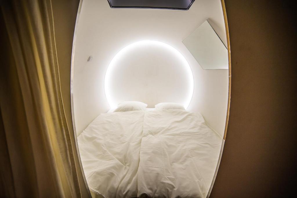 
a white bed with white sheets and a lamp at Sleep&Go in Prague
