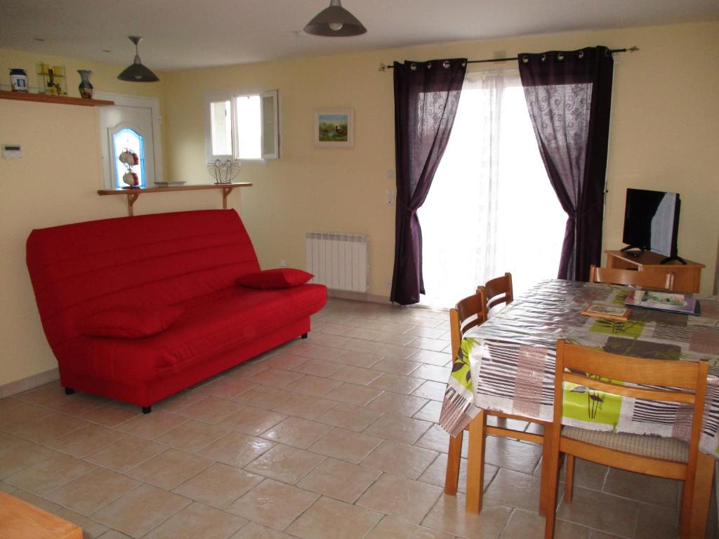 sala de estar con sofá rojo y mesa en Logement Soulac sur mer, en Soulac-sur-Mer