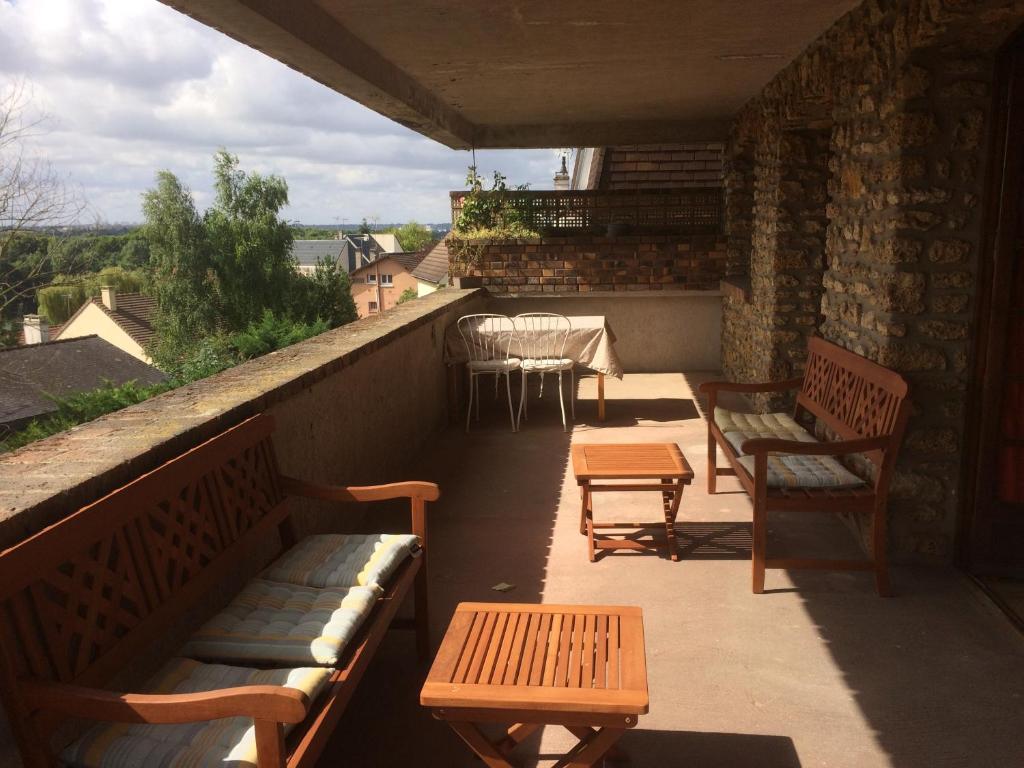 einen Balkon mit Bänken, einem Tisch und Stühlen in der Unterkunft Appartement avec terrasse pour 4 personnes in Athis-Mons