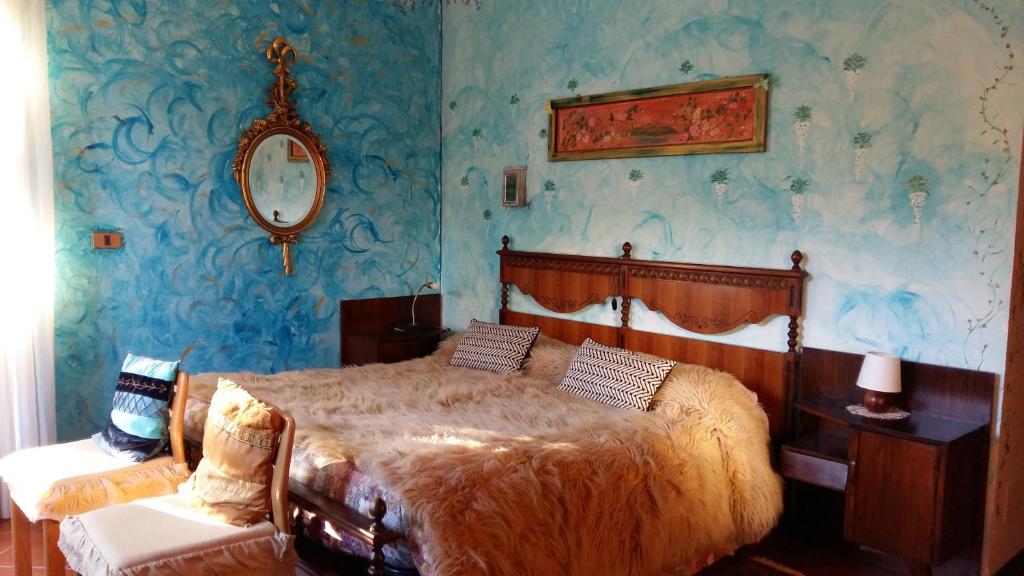 1 dormitorio con 1 cama y paredes azules en Il Nido del Pettirosso, en Borgomanero