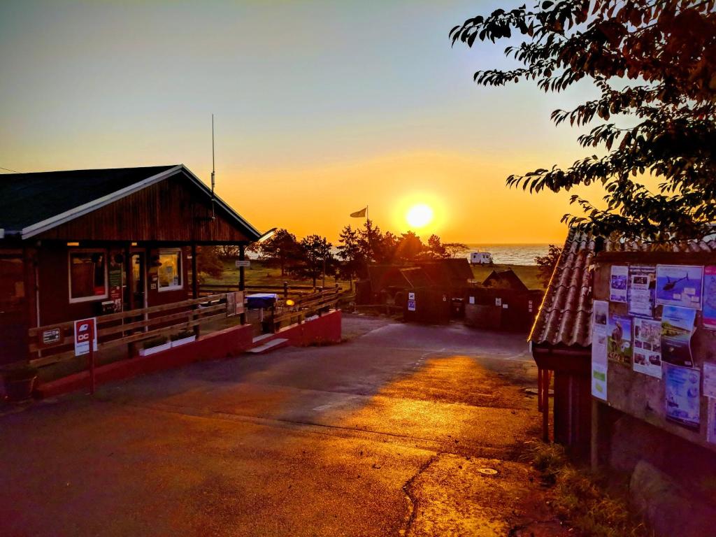 un tramonto su un edificio con il tramonto sullo sfondo di Nexø Camping & Cabins a Neksø