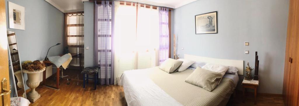 a bedroom with a white bed and a large window at Baldissera in Estella