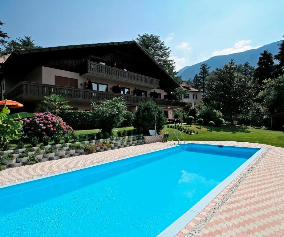 a swimming pool in front of a house at Hotel Schönbrunn in Merano